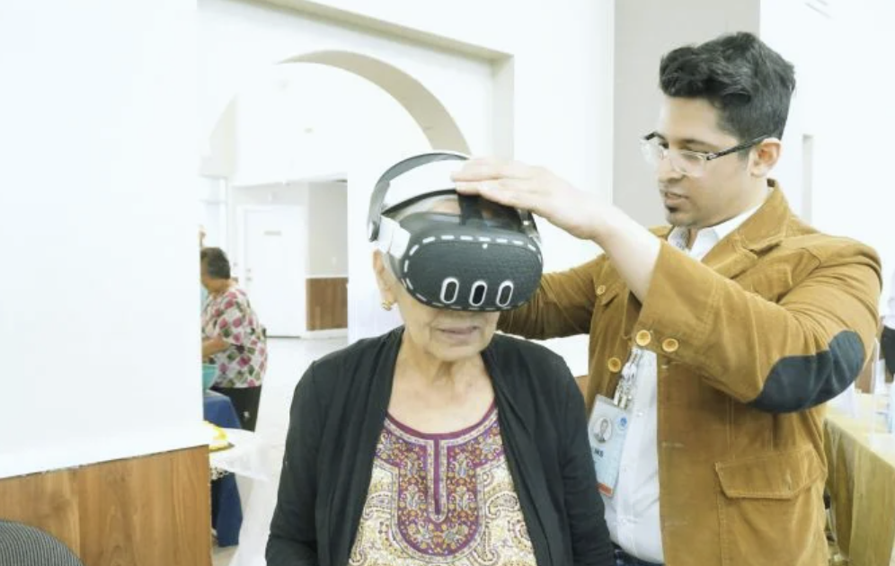 Facilitator supporting headset fitting during Immersive Mind & Memory Program (IMMP) delivery